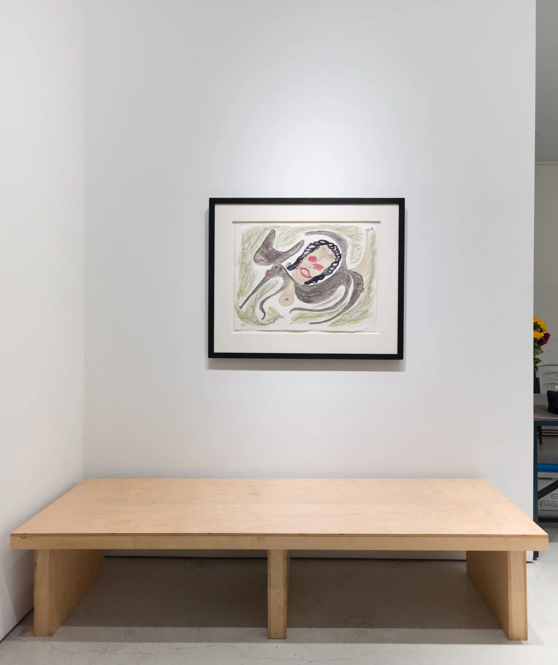 Minimalist gallery interior with light wood bench and framed abstract artwork on white wall above.