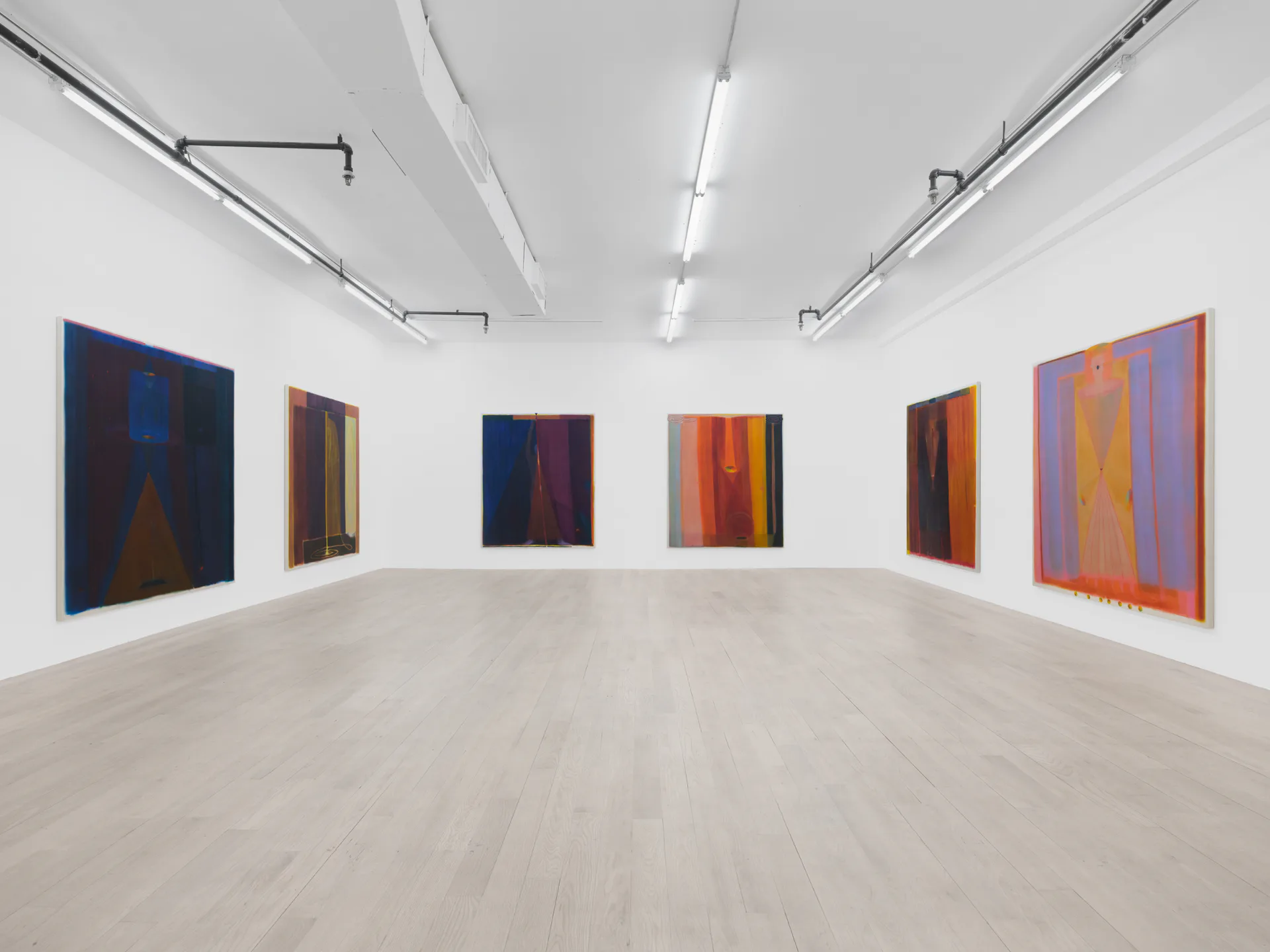 Gallery interior with color-field abstract paintings in blues, oranges, and reds hung on white walls, light wood flooring.