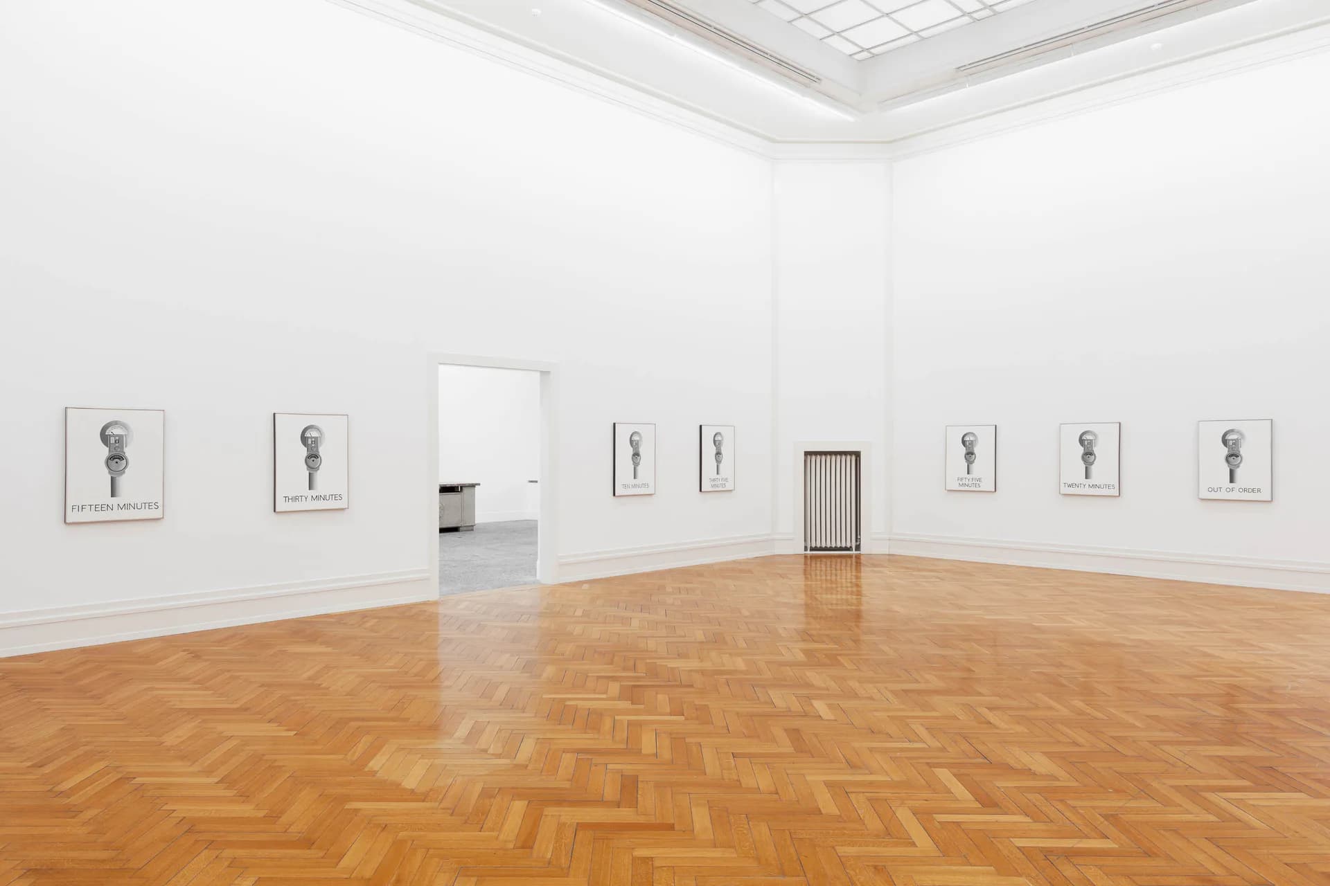 Gallery interior with herringbone wood floor, white walls, framed line drawings, and white doorway at Maxwell Graham / Essex Street.