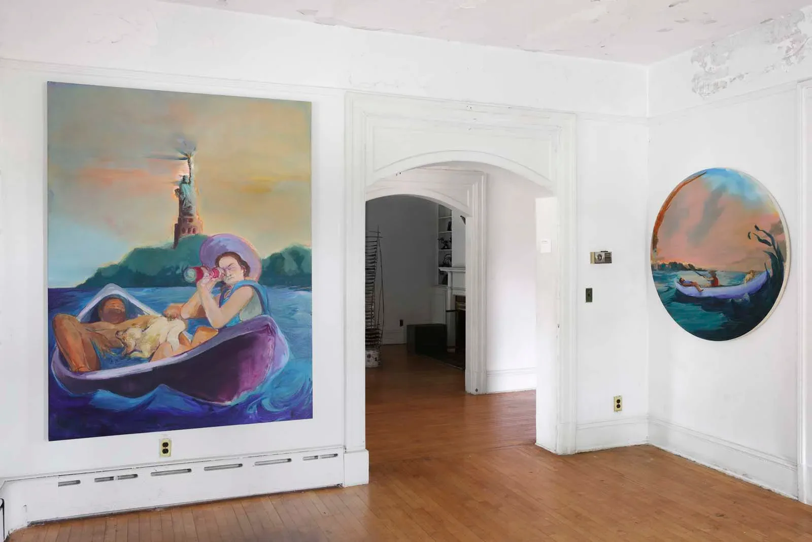 Gallery space with wooden floor, large rectangular colorful painting of figures in boat with purple water, and circular painting on right wall, white walls and doorway visible.