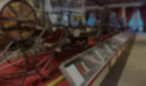 Blurry interior view of the New York City Fire Museum showing antique red fire wagons and wheeled equipment displayed along a gallery hall
