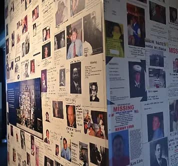 Interior wall covered with numerous missing persons flyers and photographs, part of a memorial display at the New York City Fire Museum