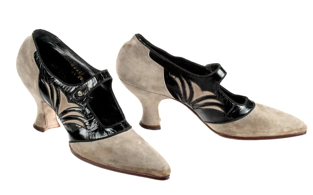 Pair of beige suede heels with black patent leather zebra-stripe detail, kitten heels, vintage dancing shoes.