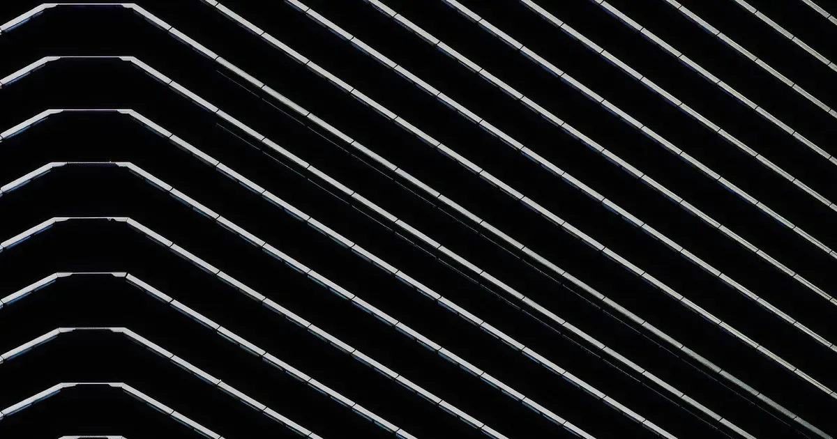 Abstract minimalist drawing of parallel diagonal white lines on black background, creating a wave-like striped pattern.
