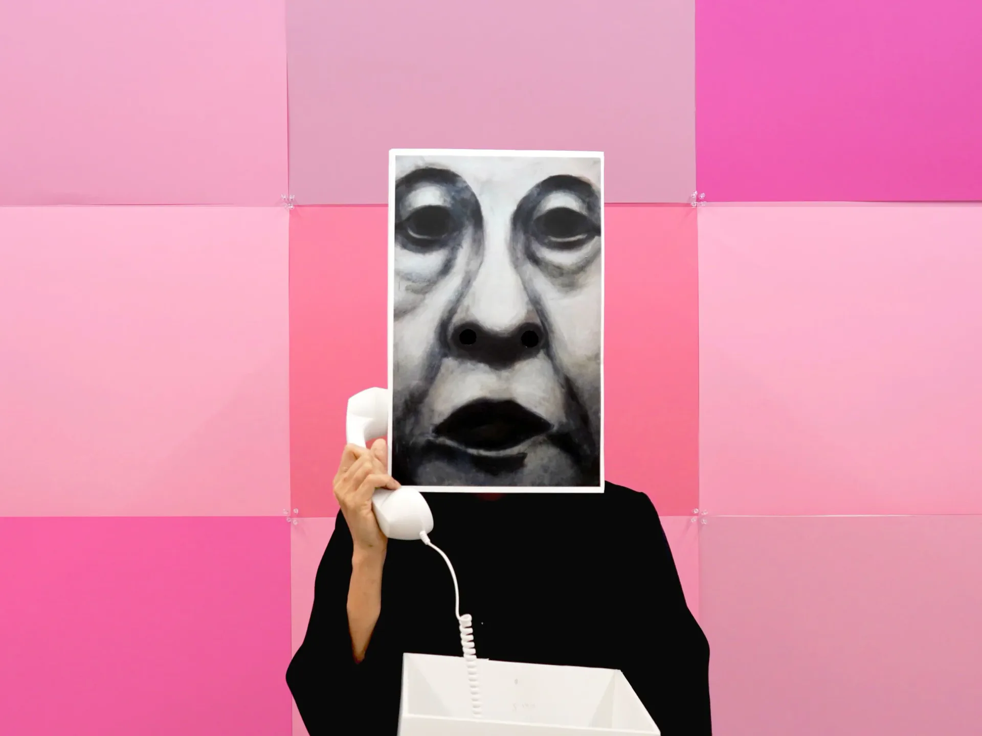 Conceptual mixed-media artwork: person in black clothing holding a black-and-white photograph of a face against a gradient pink geometric background.