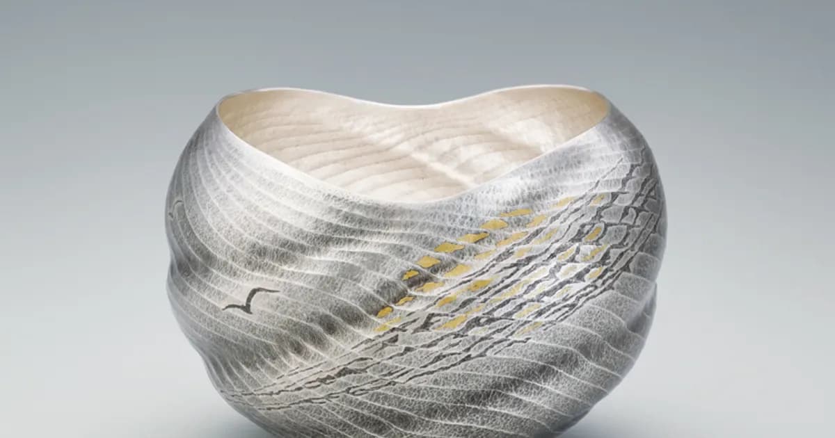 Contemporary silver metallic sculptural form with organic, flowing twisted surface and subtle gold linear accents.