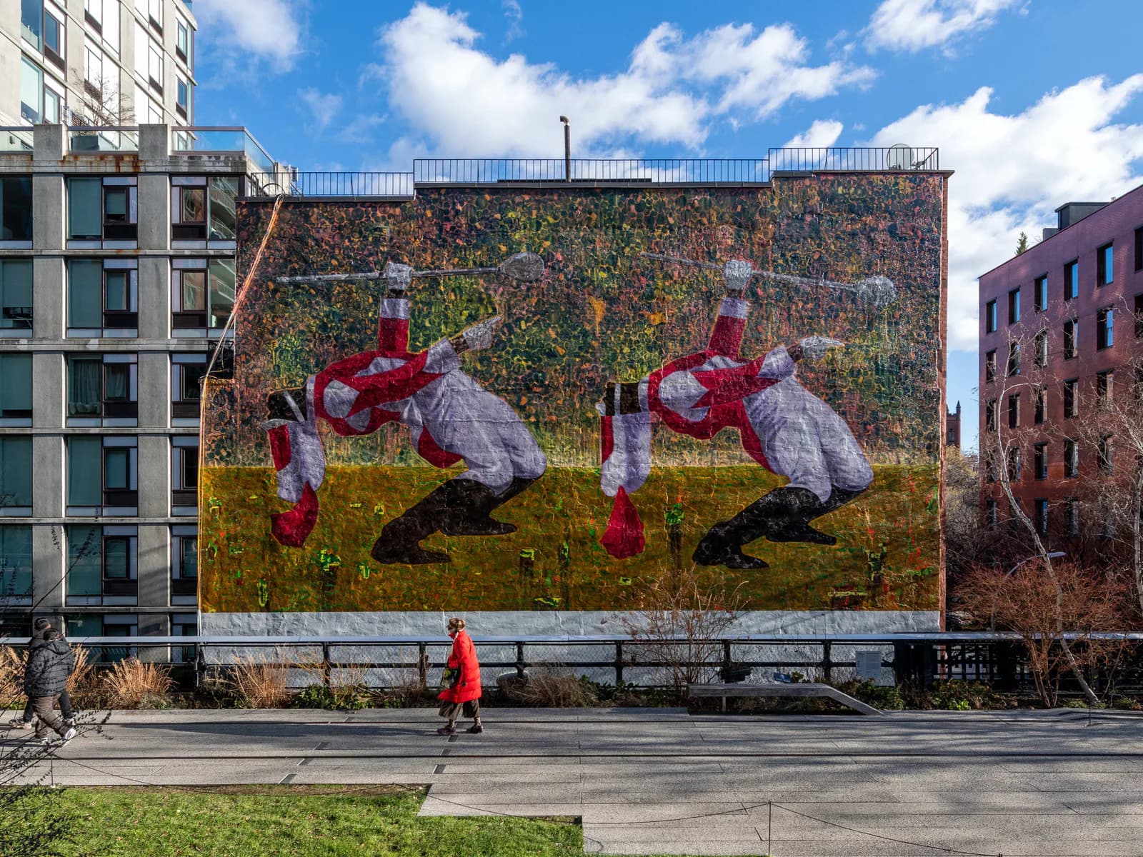 Large-scale mural on urban building facade depicting two mirrored figures in white shirts and red pants against yellow and green background with climbing vines.