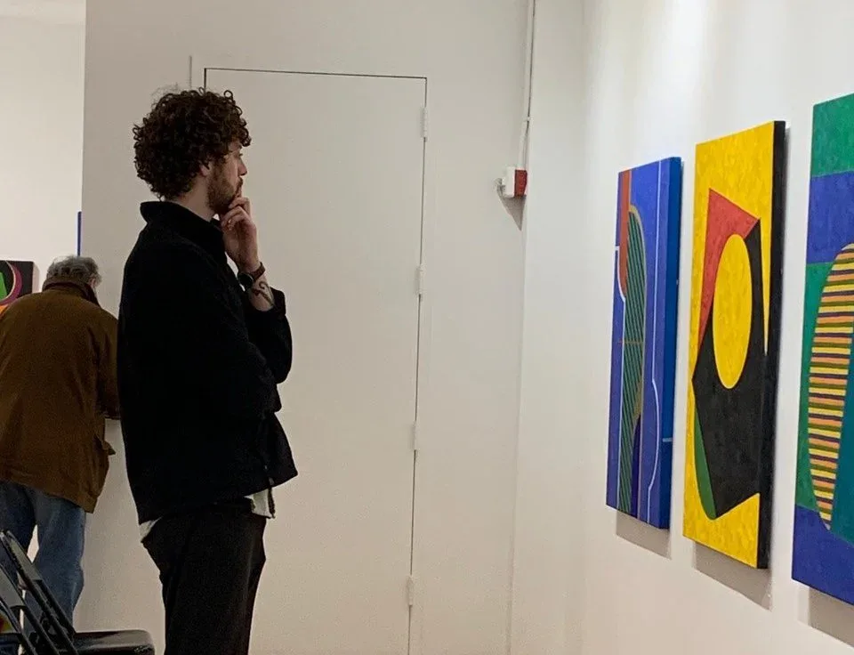 Interior of Pleiades Gallery with visitors viewing colorful abstract artworks hung on white walls in Chelsea.