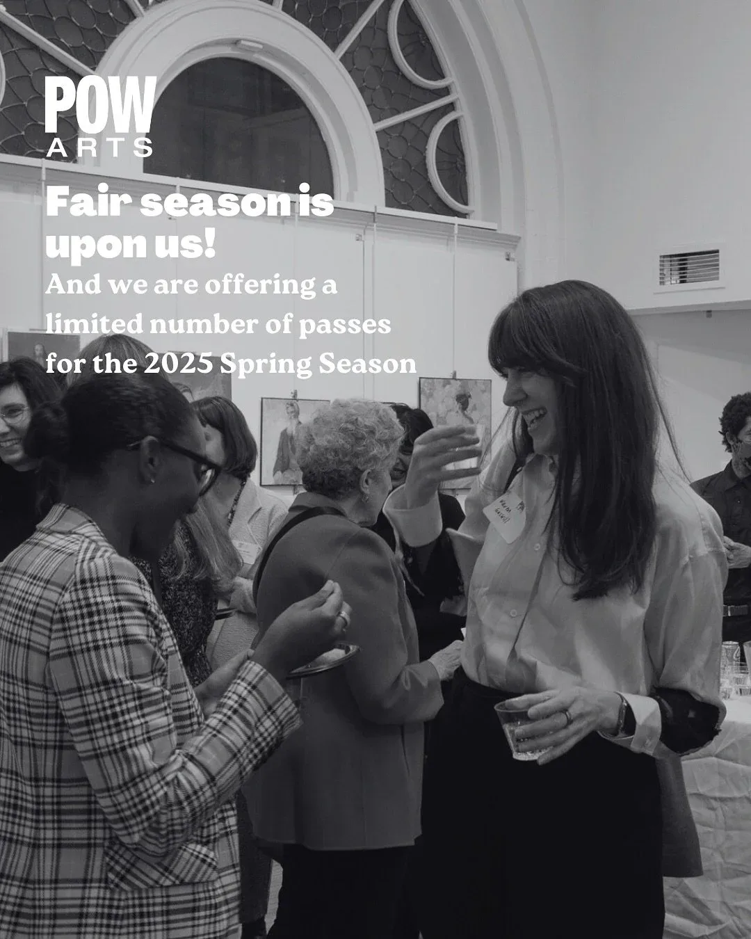 Black and white photograph of people gathered indoors at Professional Organization for Women in the Arts event discussing 2025 Spring Season pass offerings.