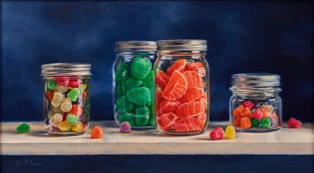 Four glass jars of varying sizes filled with colorful gummy candies arranged in gradient arrangement against dark blue background, still-life photograph.