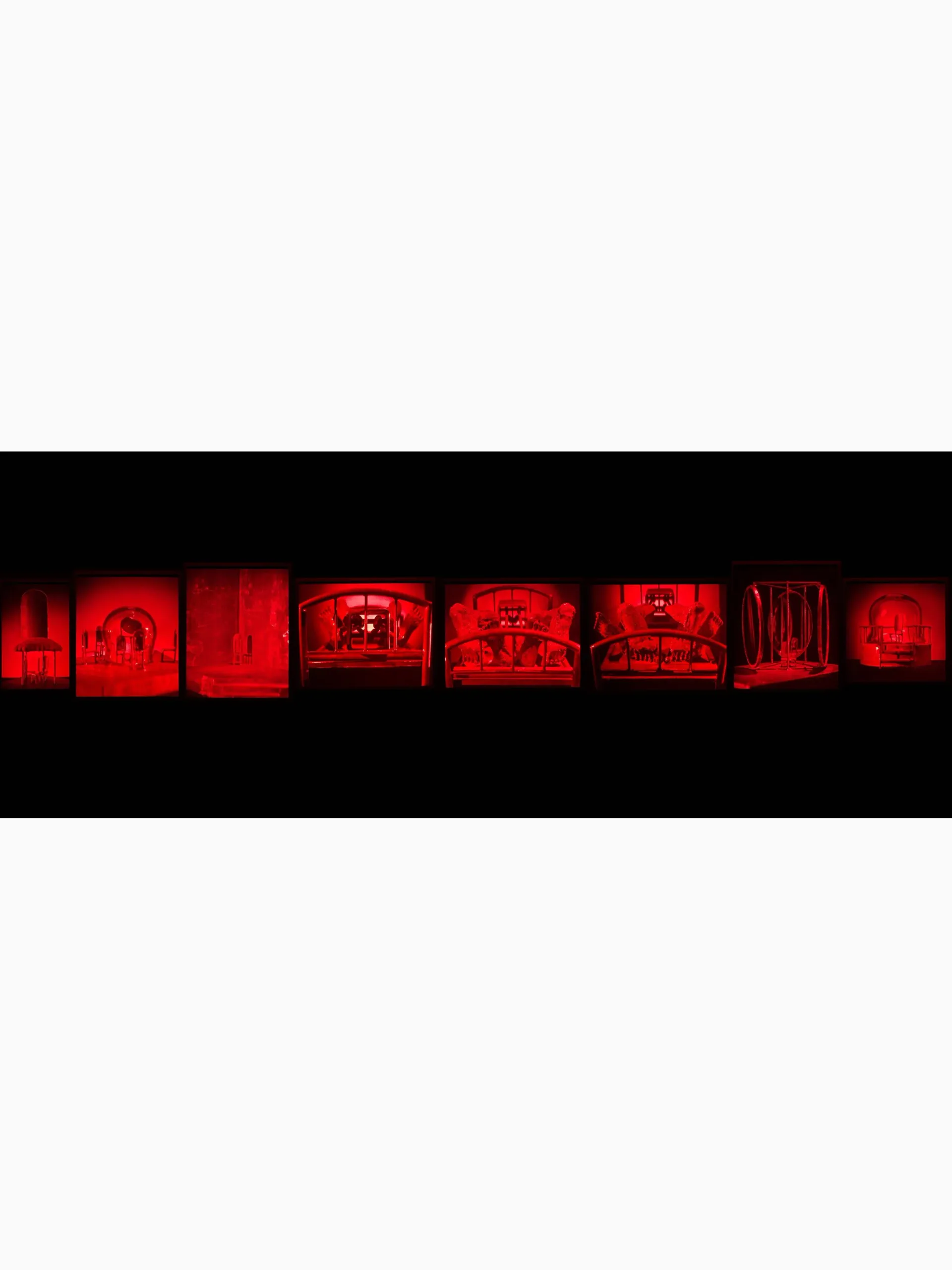 Eight glowing neon red sculptural forms arranged horizontally against black background.