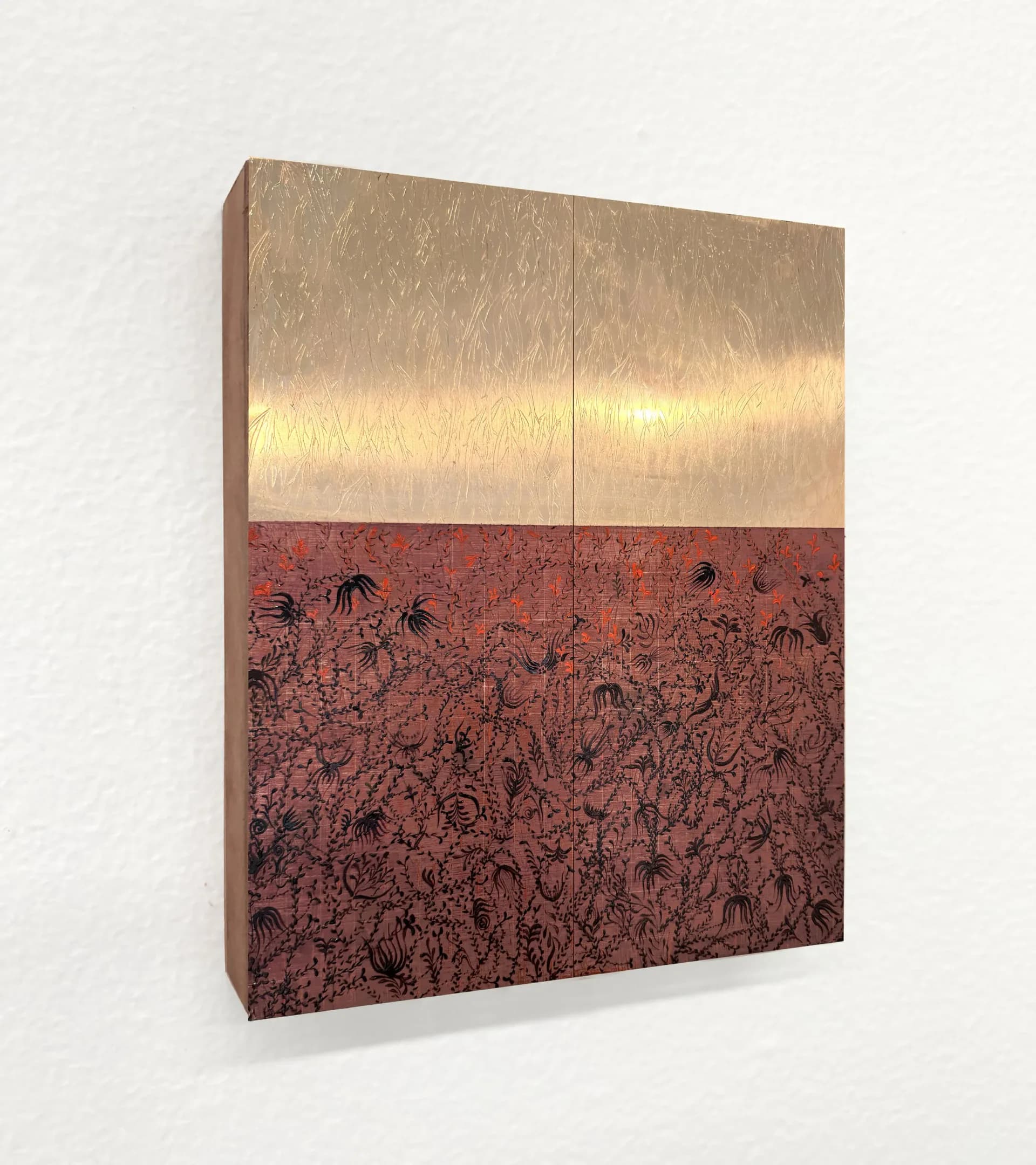 Mixed-media panel with polished metallic upper half and intricate burgundy-red patterned lower section, hung on white wall.
