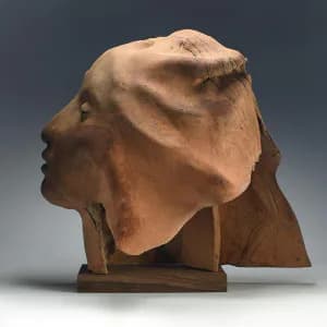 Terracotta sculptural bust with draped cloth element, rendered in warm earthen tones against neutral background.