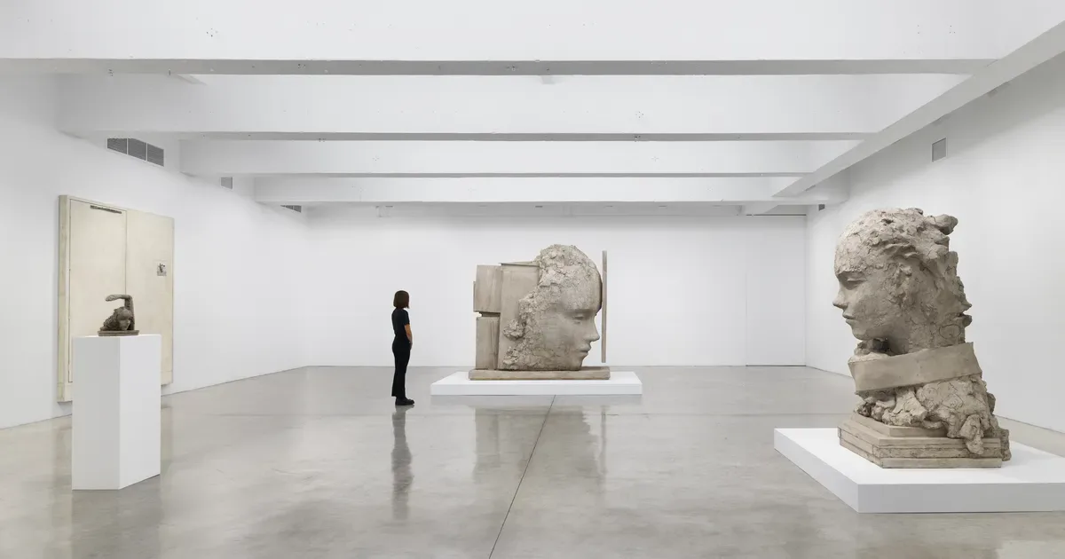 Minimalist gallery interior with polished concrete floor, white walls, and three stone sculptural works on pedestals at Tanya Bonakdar Gallery.