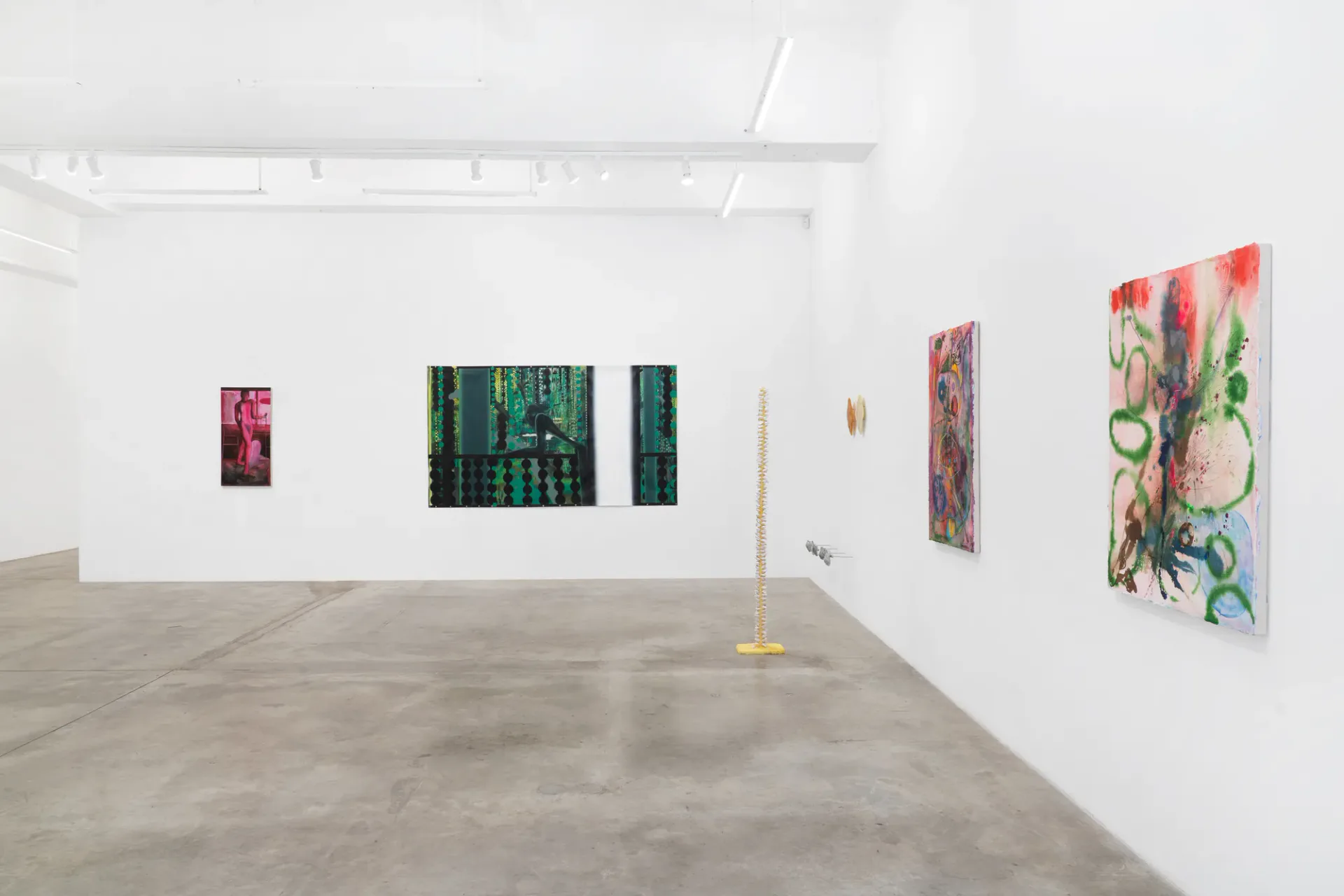 Gallery interior at Tina Kim Gallery showing white walls with mounted colorful abstract artworks, concrete floor, clean minimalist presentation.