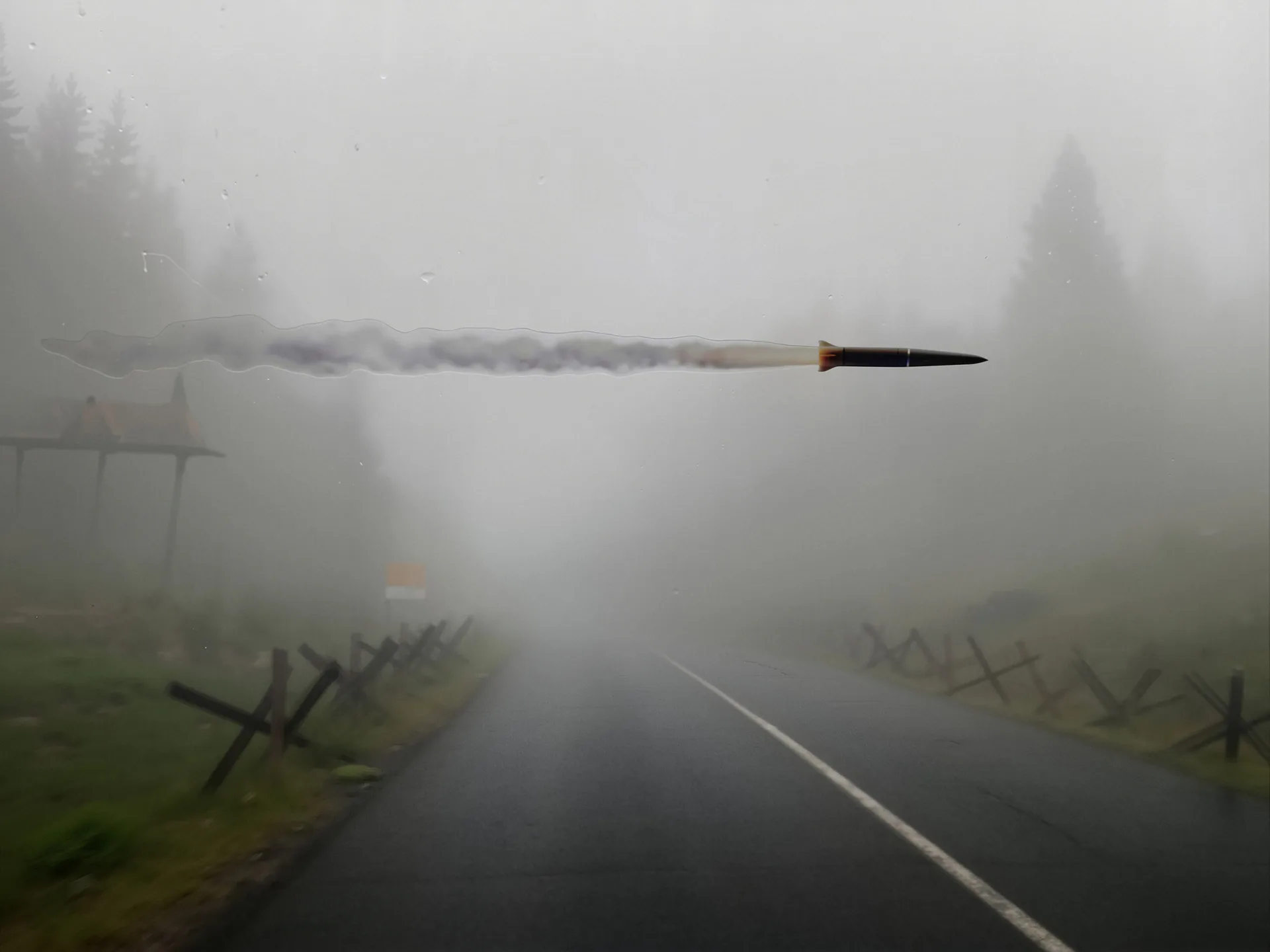 Misty landscape painting: empty road stretching through fog-shrouded forest with wooden fence posts on either side.